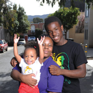 family smiling in residential neighborhood