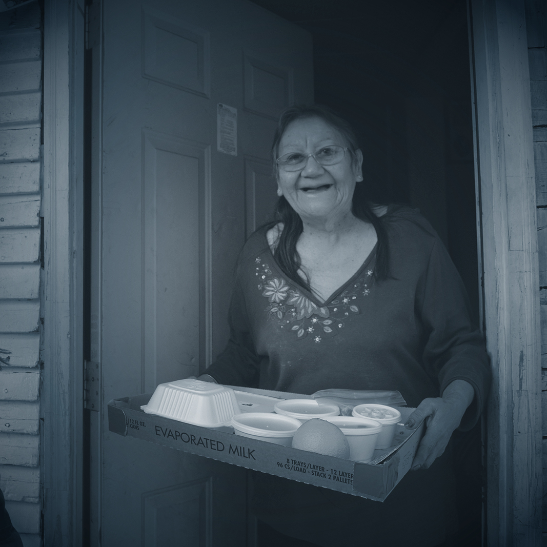 senior with a tray of baked goods