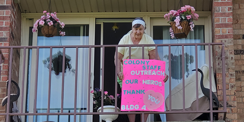 Woman on balcony with sign