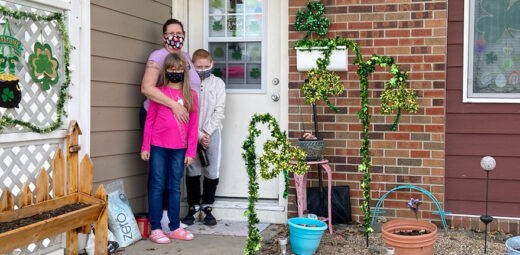 Mother standing by front door with two children