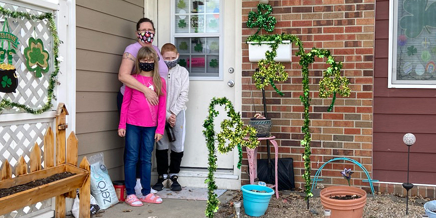 Mother standing by front door with two children