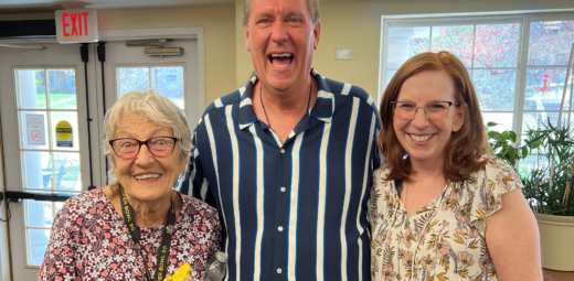A man and two women at a Mercy Housing community smiling at the camera