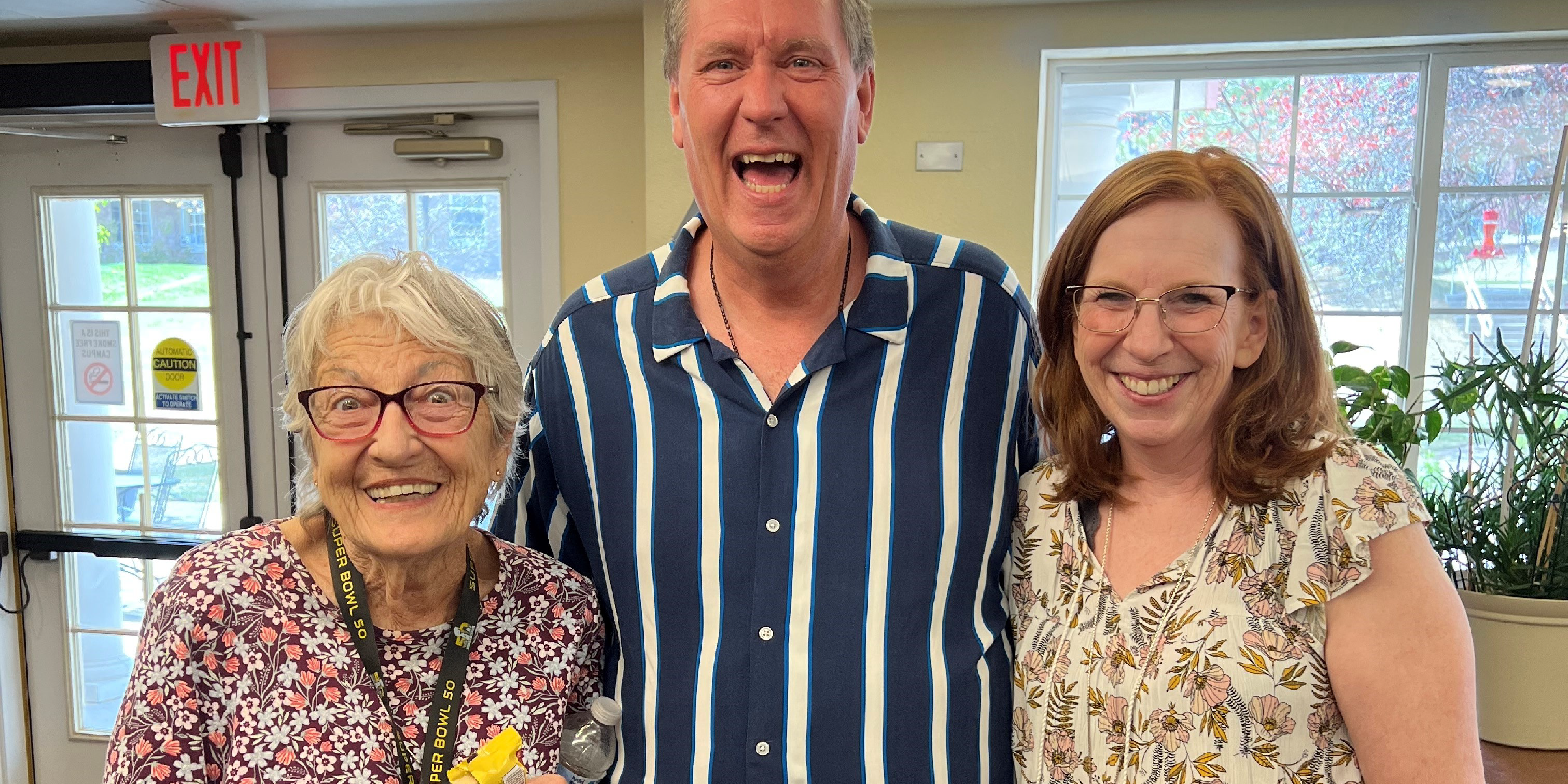 A man and two women at a Mercy Housing community smiling at the camera